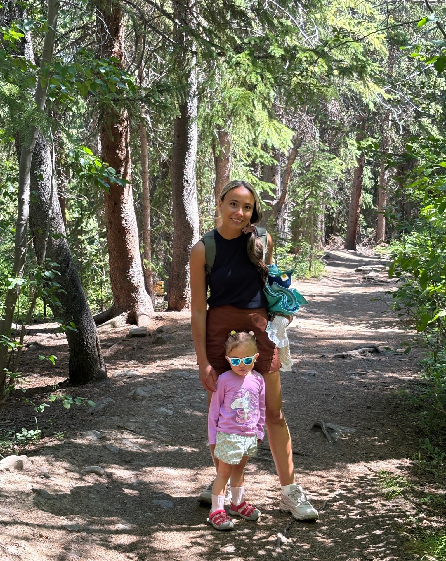 Scarlet smiling with her little one on a sunny forest trail